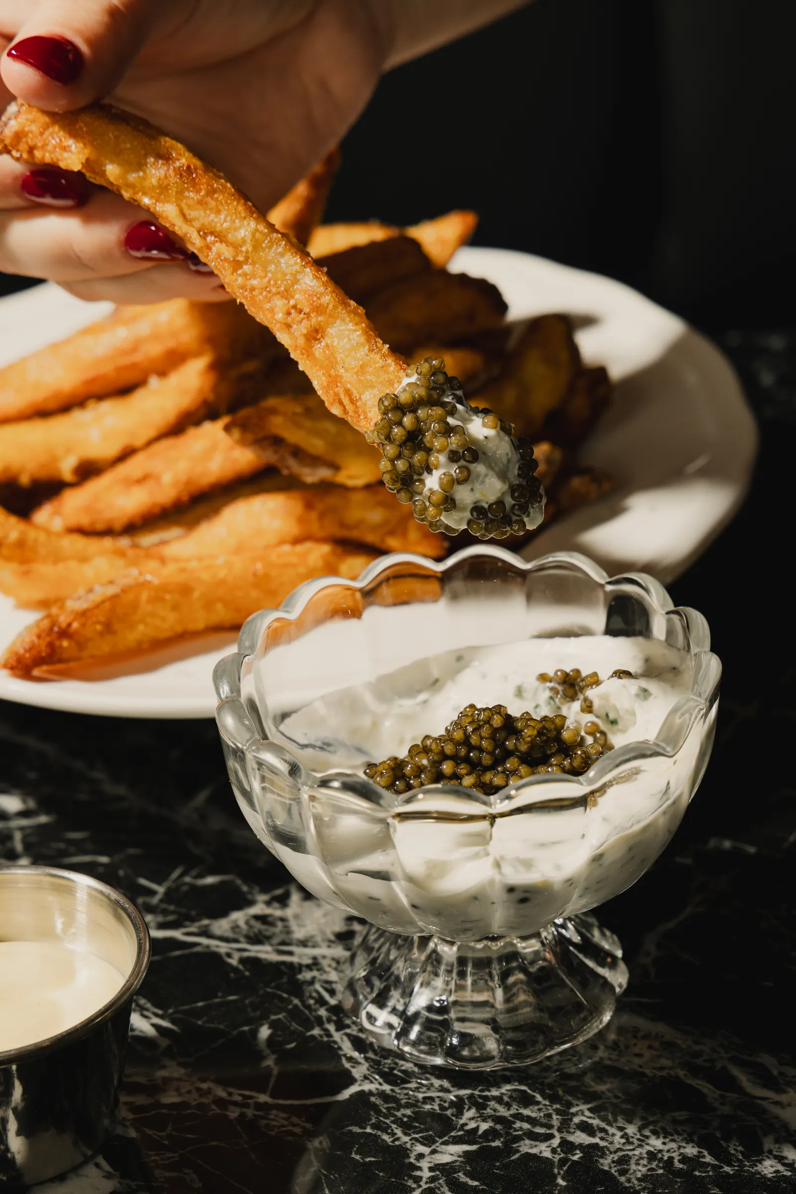 Frites dipped in caviar and creme fraiche